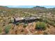 Aerial view of a house with solar panels and desert landscaping, set against a mountain backdrop at 10860 E Cactus View Cir, Gold Canyon, AZ 85118