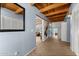 Light and airy entry hall with exposed wood beams and tile flooring at 56444 N Vulture Mine Rd, Wickenburg, AZ 85390