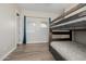 A bedroom with a bunk bed, two windows, and teal curtains at 18211 W Sequoia Dr, Goodyear, AZ 85338