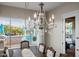Elegant dining room features a crystal chandelier and views of the backyard pool at 18211 W Sequoia Dr, Goodyear, AZ 85338