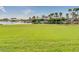 Large grassy park area with palm trees and a water park in the background at 18211 W Sequoia Dr, Goodyear, AZ 85338