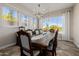 Formal dining room with a large table, chandelier, and pool view at 18211 W Sequoia Dr, Goodyear, AZ 85338