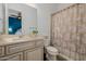 Bathroom with beige vanity, shower, and floral curtain at 18211 W Sequoia Dr, Goodyear, AZ 85338