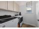 Laundry room with Whirlpool washer and dryer, cabinets and window at 18211 W Sequoia Dr, Goodyear, AZ 85338