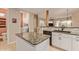 Kitchen with granite countertop island, white cabinets, and a laundry area at 6069 E Knolls S Way, Cave Creek, AZ 85331