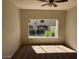 Bright living room with large window and carpeted floor at 3236 E Chandler Blvd # 1033, Phoenix, AZ 85048