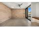 Bright bedroom with polished concrete floors, a wood accent wall, and large windows at 7501 E Palo Verde Dr # 8, Scottsdale, AZ 85250