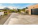 Long concrete driveway leading to a modern brick home with a black garage door at 7501 E Palo Verde Dr # 8, Scottsdale, AZ 85250