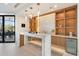 Stylish modern bar area with marble counter, wood shelving, and backyard access at 9701 E Happy Valley Rd # 10, Scottsdale, AZ 85255