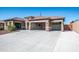 A charming house exterior featuring a three-car garage and attractive landscaping at 43856 N Hudson Trl, New River, AZ 85087