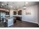 Open concept kitchen with large island, granite counters, and dark wood cabinets at 43856 N Hudson Trl, New River, AZ 85087