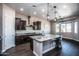 Spacious kitchen featuring granite countertops, dark wood cabinetry, and a large island at 43856 N Hudson Trl, New River, AZ 85087