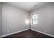 Simple bedroom with a large window and wood flooring at 43856 N Hudson Trl, New River, AZ 85087