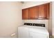Laundry room with washer, dryer, and upper cabinets at 23014 N 86Th St, Scottsdale, AZ 85255