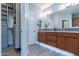 Bathroom with double sinks, large mirror, and walk-in shower at 36131 N Desert Tea Dr, Queen Creek, AZ 85140