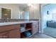 Double vanity bathroom with modern wood cabinets and tile accents at 36131 N Desert Tea Dr, Queen Creek, AZ 85140