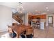 Modern dining area with a wood table and chairs, near kitchen and staircase at 36131 N Desert Tea Dr, Queen Creek, AZ 85140