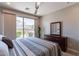 Comfortable bedroom with a queen-size bed, dresser and access to backyard at 36131 N Desert Tea Dr, Queen Creek, AZ 85140