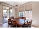 Bright dining area with a wood table and six chairs, adjacent to sliding glass doors at 36131 N Desert Tea Dr, Queen Creek, AZ 85140