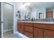 Bathroom with double sinks, a toilet, and a large mirror at 36131 N Desert Tea Dr, Queen Creek, AZ 85140