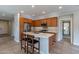 Modern kitchen with a breakfast bar, stainless steel appliances, and light wood cabinets at 36131 N Desert Tea Dr, Queen Creek, AZ 85140
