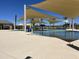 Resort-style pool with shade structures and a water feature at 16035 W Questa Dr, Surprise, AZ 85387