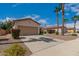 Tan house with brown garage door, desert landscaping, and palm trees at 1940 S Talbot Cir, Mesa, AZ 85209