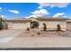Tan two-story house with a two-car garage and desert landscaping at 14194 W Mountain Laurel Trl, Surprise, AZ 85374