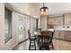 Eat-in kitchen with wood cabinetry, tile flooring, and access to the backyard at 14194 W Mountain Laurel Trl, Surprise, AZ 85374