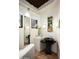Stylish powder room with pedestal sink, unique mirror, and modern lighting at 42035 N 113Th Way, Scottsdale, AZ 85262