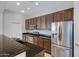 Kitchen with dark wood cabinets, granite counters, and stainless steel appliances at 15240 N 142Nd Ave # 2111, Surprise, AZ 85379