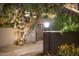 Inviting entryway with pathway, gate, and string lights illuminating the way at 8420 N 15Th St, Phoenix, AZ 85020