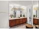 Bathroom with double sinks, wood cabinets, and a large mirror at 26348 N 104Th Way, Scottsdale, AZ 85255