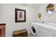 Laundry room with washer, dryer, and wooden storage chest at 26348 N 104Th Way, Scottsdale, AZ 85255