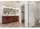 Bathroom with double vanity, large mirror, and walk-in closet at 7311 N 90Th Ave, Glendale, AZ 85305