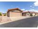 Tan house exterior with a two-car garage and desert landscaping at 3301 S Goldfield Rd # 3004, Apache Junction, AZ 85119