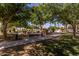 Paved pathway meanders through lush landscaping with a shaded bench at 3301 S Goldfield Rd # 3004, Apache Junction, AZ 85119