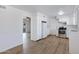 White kitchen with stainless steel appliances and wood-look flooring at 6027 E Duncan St, Mesa, AZ 85205