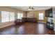 Living room with hardwood floors, large windows, and a cozy leather sectional at 44449 W Canyon Creek Dr, Maricopa, AZ 85139