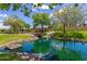 Serene community pond with stone bridge and lush landscaping at 3432 E Strawberry Dr, Gilbert, AZ 85298