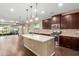 Modern kitchen with a large island, stainless steel appliances, and dark wood cabinets at 3432 E Strawberry Dr, Gilbert, AZ 85298