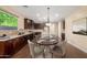 Modern kitchen with a dining area, stainless steel appliances and dark wood cabinets at 3432 E Strawberry Dr, Gilbert, AZ 85298