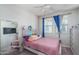 Bright bedroom with a pink bed and large mirror at 15161 W Pierce St, Goodyear, AZ 85338