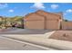 Two-car garage with a tan stucco exterior and a well-maintained driveway at 1731 W Cathedral Rock Dr, Phoenix, AZ 85045