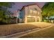 Night view of home's exterior, showcasing two-car garage and landscaping at 10015 N 55Th St, Paradise Valley, AZ 85253