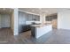 Modern kitchen with gray cabinets, quartz island, and tile floors at 39980 W Bunker Dr, Maricopa, AZ 85138