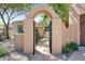 Inviting entryway with an arched gate and landscaping at 6711 E Camelback Rd # 3, Scottsdale, AZ 85251