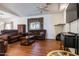 Comfortable living room with brown sofas, wood flooring, and a ceiling fan at 8183 W Raven Dr, Arizona City, AZ 85123