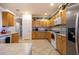 Open kitchen boasts wood cabinets, tile floors, and stainless steel appliances at 8183 W Raven Dr, Arizona City, AZ 85123