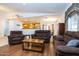 Open living room with brown sofas, wood flooring, and kitchen views at 8183 W Raven Dr, Arizona City, AZ 85123